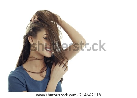 Portrait of a gorgeous smiling woman playing on her face with a lock of her long silky hair, isolated on white.