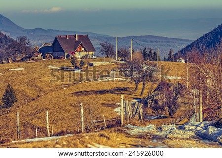 Peaceful Romanian rural scene with traditional farm and grassland uphill in Moeciu, Brasov county, Trasylvania region, Romania. Trekking destinations.