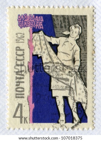 USSR - CIRCA 1962: Postage stamp printed in the Soviet Union shows a woman with a piece of fabric. Textile industry. Slogan - For the benefit of man, circa 1962