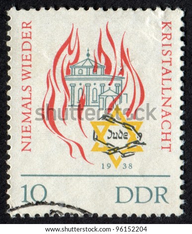 DDR - CIRCA  1963: Postage stamp printed in DDR shows a Synagogue in Fire and Star of David (Magen David) in Barbed Wire (Chains). Kristallnacht. Niemals Wieder. 1938, circa 1963