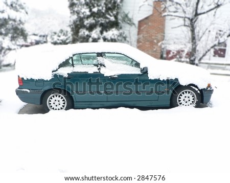 photo of a snow covered vehicle in home driveway during a winter snow storm