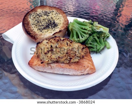 dinner of salmon stuffed with crabmeat with brocolli and garlic bread on the side