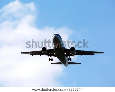 commercial jet in flight with a bright blue sky in the background. copy space included