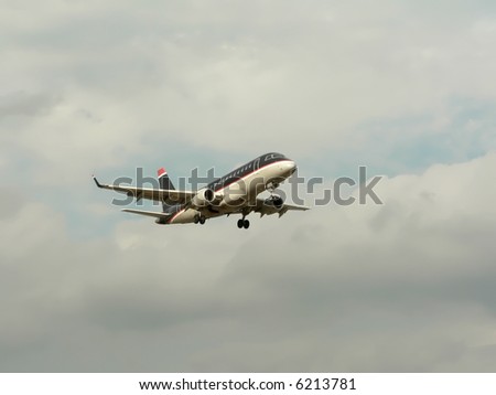 commercial jet in flight with a cloudy blue sky in the background. copy space included