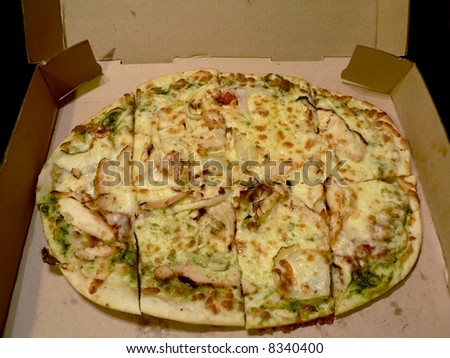 photo of a open pizza box with pesto chicken topped flatbread pizza inside