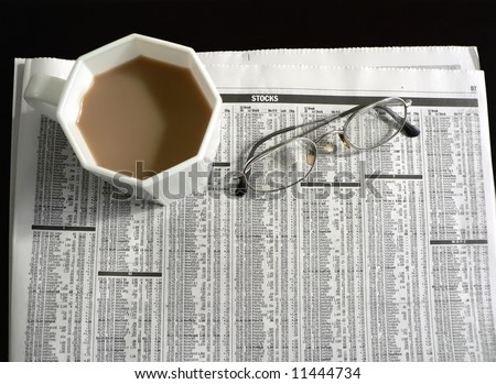 newspaper featuring the stock page with coffee and pair 0f eyeglasses