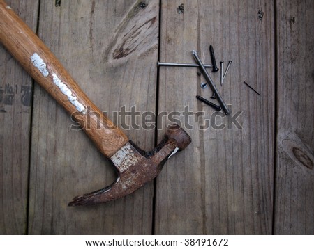 A old hammer nails, screws and wood tacks, on wood deck beams.