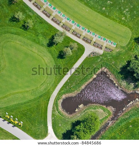 Aerial view over small lake and golf field