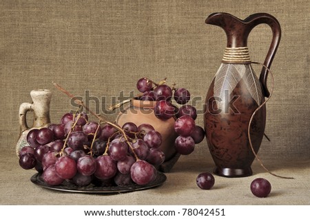 Grapes red and ceramic ware against a canvas