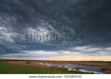 Dramatic storm sky and ominous clouds over lake in April