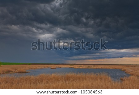 Dramatic storm sky and ominous clouds over lake in April