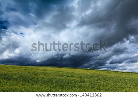 Countryside with wheat field and ominous stormy sky