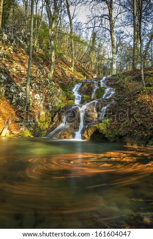 Beautiful autumn foliage, waterfalls and reflection patterns in mountain stream in the forest