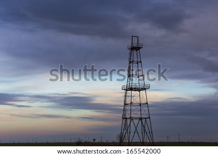 Abandoned oil and gas rig profiled on sky - stock photo