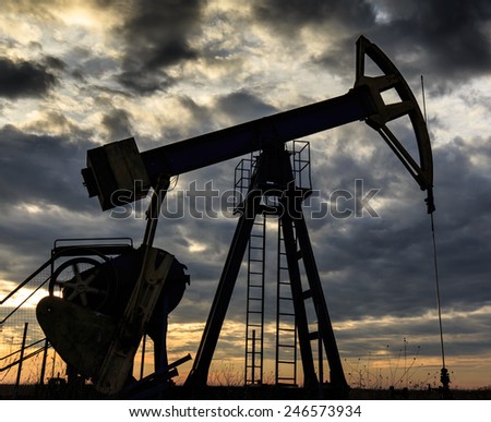 Close-up of industrial oil and gas pump, profiled on storm clouds