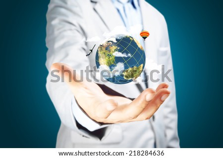 Business male hand hold earth globe on blue background. Elements in this image furnished by NASA.