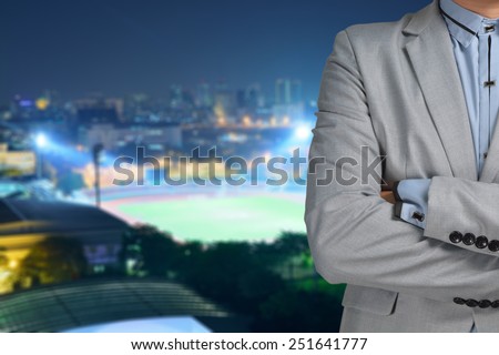 Business man sport manager and executive with background of soccer ball athletic stadium and race track