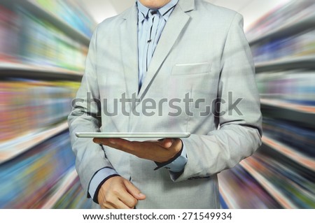 Business Man Holding Tablet in Supermarket outlet as Retail Wireless Technology.  Double exposure applied.