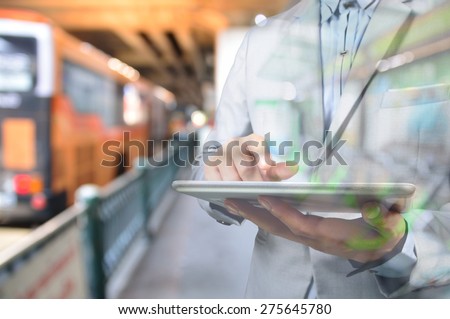 Business Man using Mobile Digital tablet in Bus Station as Time Management with Wireless Device Concept