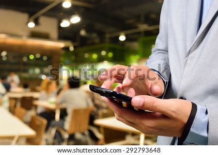 Business man using mobile smart phone in Restaurant or Food Court Plaza