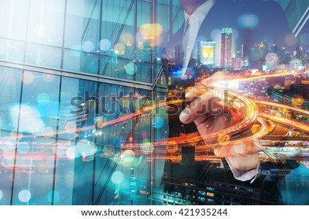 Double Exposure of Businessman draw Something with City Traffic Scene at Night and Glass decorated Building