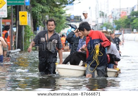 BANGKOK - OCTOBER 29: Unidentified Rescue team rescue old woman flood victim and her dog during Thai flood crisis on October 29, 2011 on west side of Chaopraya river, Bangkok, Thailand.