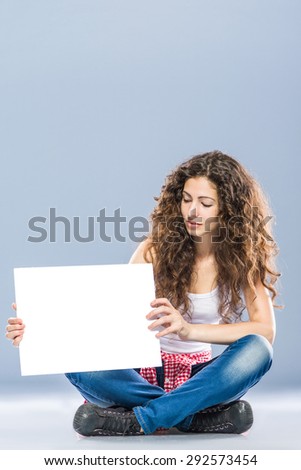 Woman billboard sign. Young beautiful woman smiling showing blank white placard.