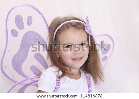 Portrait of a beautiful little girl in the image of fairy or elf with wings