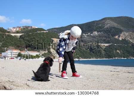 A child with a dog in the fresh air from the sea