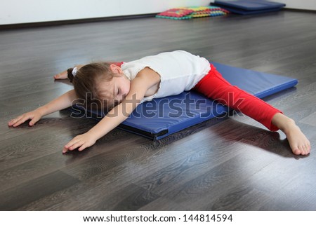 A child in a gym with a yoga session