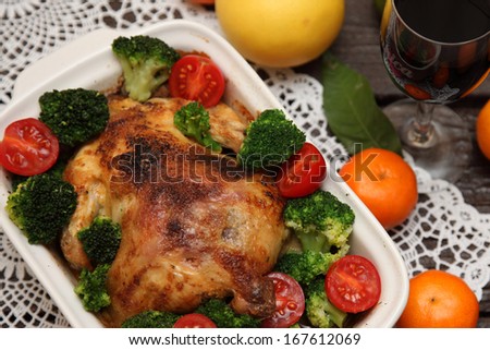 Roasted chicken seasoned with herbs. Chicken with vegetables broccoli, tomatoes, cherry tomatoes. Foodstyle.