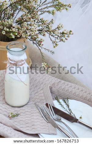 A jug of milk which is on a wicker tray. Food delivery. Food-style