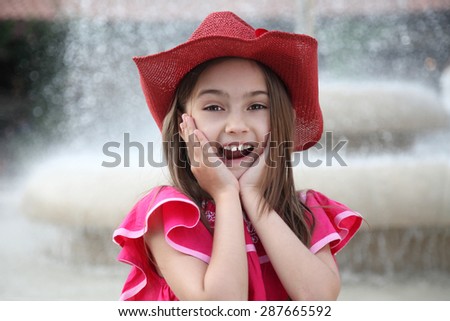 Cute girl is holding her face in astonishment. A child with an expression of happiness and surprise on his face
