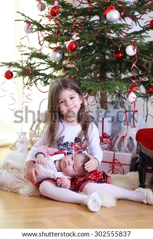 Little girl in the New Year. Happy child at Christmas tree with gifts