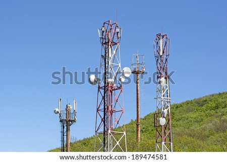 Towers with aerials of cellular on a background mountains and blue sky