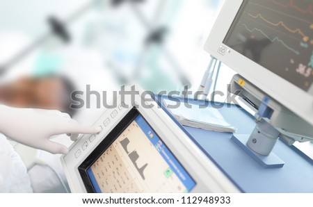 In the ICU. Doctor changes the parameters artificial lung ventilation near the bedside.
