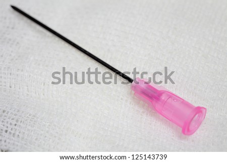 Medical needle on gauze.