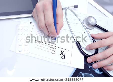 Doctor writes a prescription at his desk