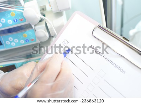 Doctor in gloves makes notes in the list