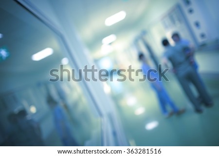 Health care workers are discussing in the hospital corridor, blurred.
