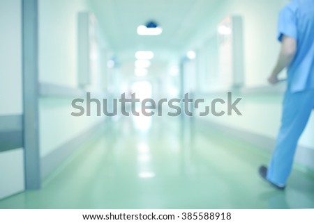 Blurred background with a hospital corridor and a moving person.