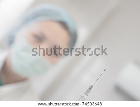 photo syringe and needle, which holds a nurse. Association with medical practice, hospital, pharmacy, medication