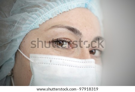 Woman in medical mask and cap. Portrait of a nurse.
