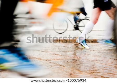 Healthy lifestyle: intentionally motion blurred abstract image of runners and bycicle. Low angle view
