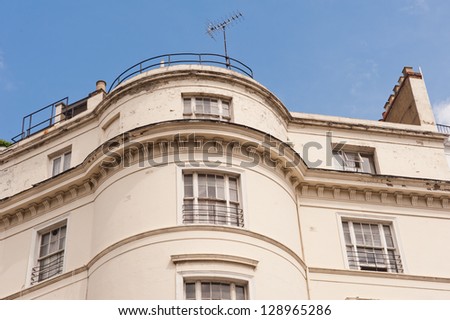 White terrace house in London. Terraced houses is a style of medium-density housing that originated in Europe in the 16th century, where a row of identical or mirror-image houses share side walls.