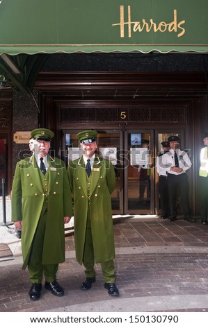 London ,Uk - Jun 15, 2013: Harrods Concierges Stand At The Store Entrance In London On June 15, 2013. With Over 330 Departments, Harrods Is The Biggest Department Store In Europe.