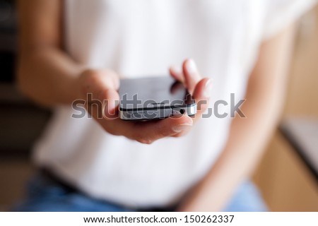 Close up of young woman handing smartphone.
