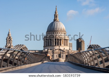 St Paul\'s Cathedral in London seen from the Millennium Bridge at sunrise on a beautiful sunny day in 2014. Available space for text on both upper sides of the image.