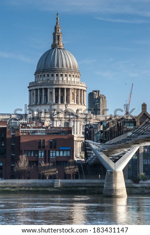 St Paul\'s Cathedral in London seen from the Millennium Bridge at sunrise on a beautiful sunny day in 2014. Available space for text on both upper sides of the image.