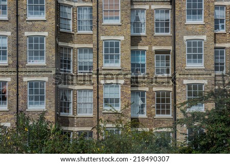 A residential house with red bricks and white windows in East London